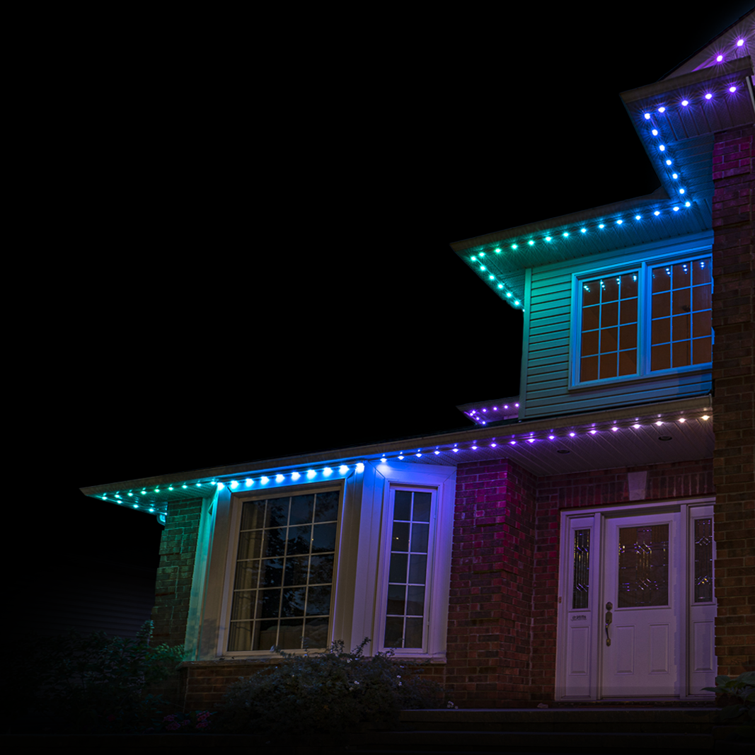 Modern home with permanent outdoor lighting in blue and purple tones illuminating the roofline at night