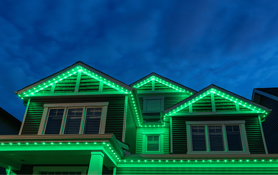 Two-storey home illuminated with Permanent Outdoor Lighting along multiple rooflines for a striking Halloween display.