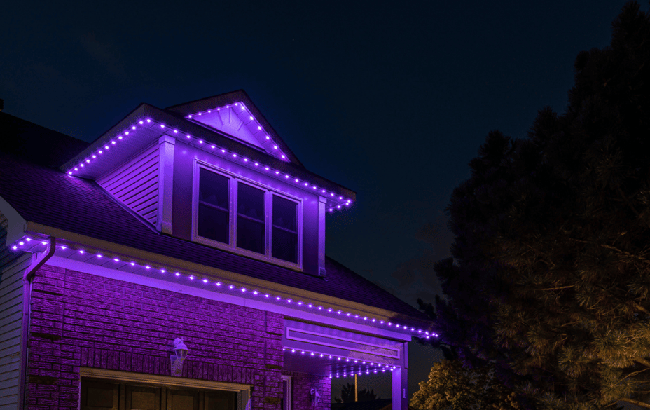 Two-storey home illuminated with Permanent Holiday Lighting along the roofline and garage for a dramatic Halloween look.