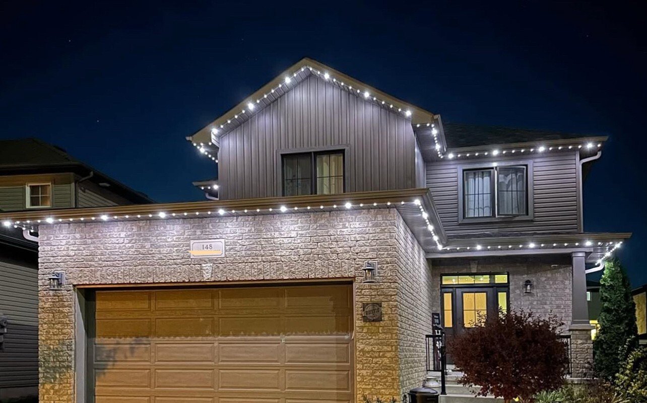 Permanent architectural lighting highlighting the roof peaks and exterior features of a contemporary home at night.