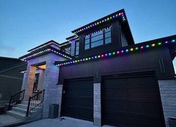 Color-changing permanent holiday lighting on a modern home, creating vibrant customizable displays for every season and celebration.