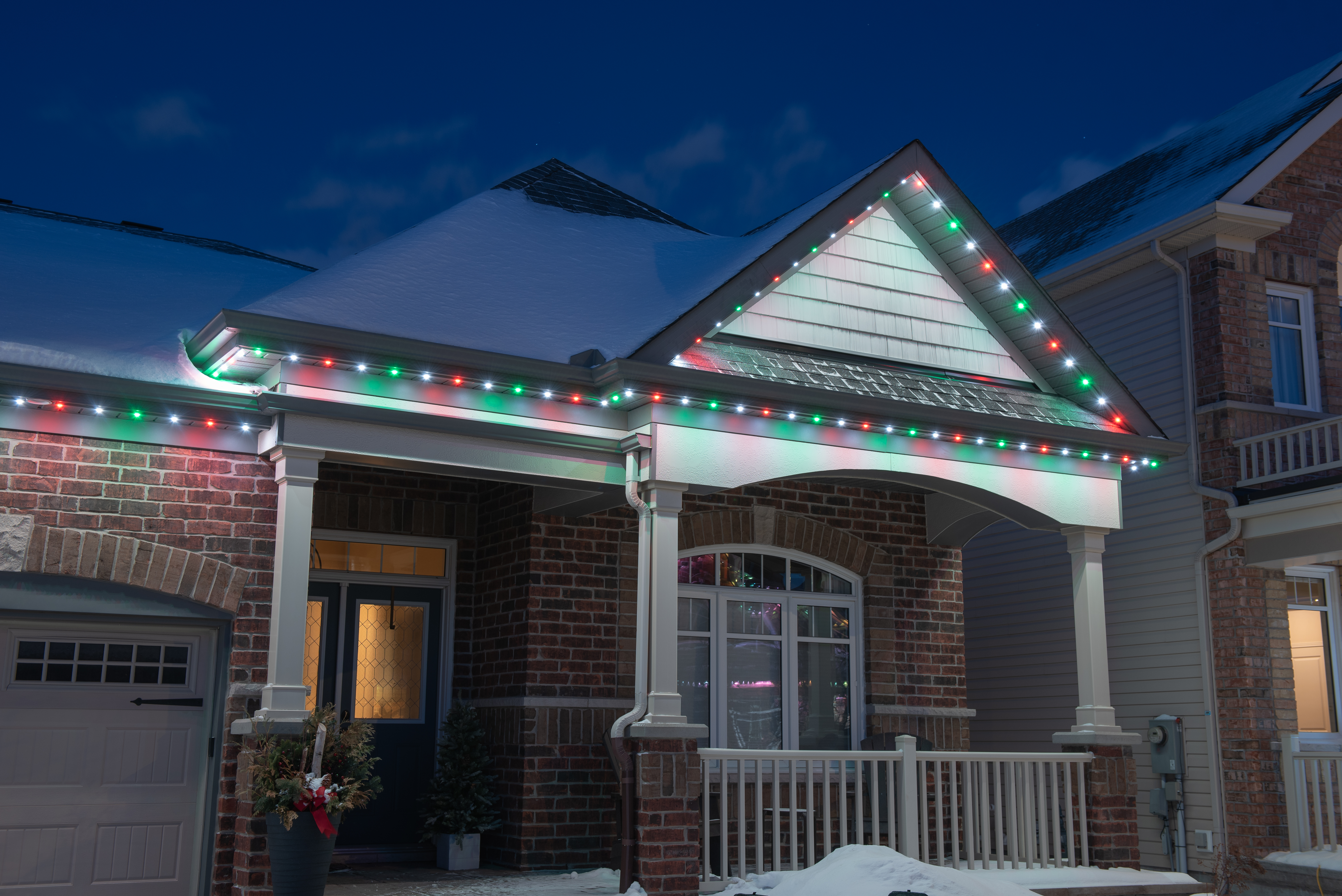 House at night with Celebright permanent lights showing the Christmas Rain preset.
