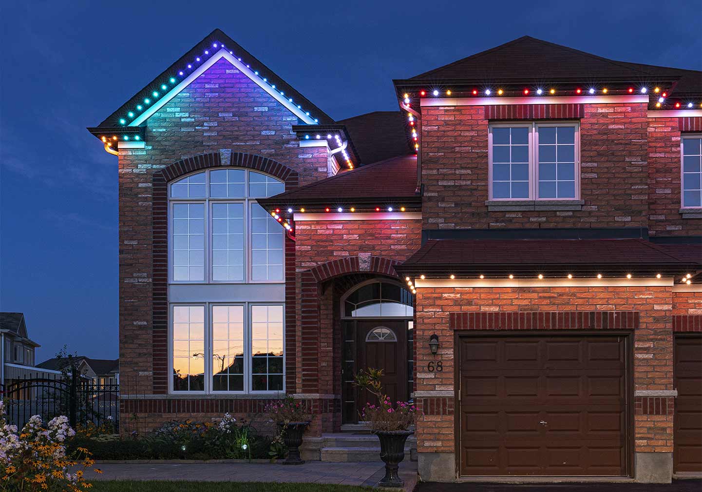 Two-story home with permanent holiday lighting showcasing different presets across the roofline