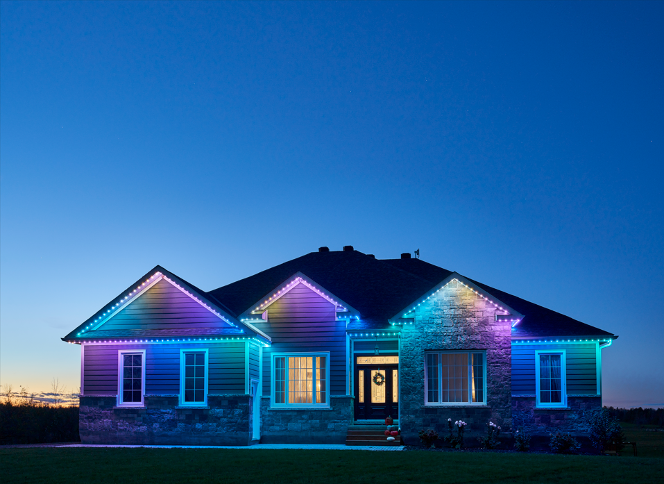 Modern home with color-changing permanent outdoor lighting at dusk