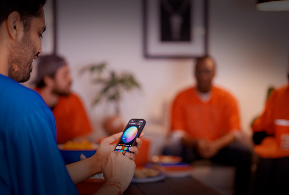 Close-up of someone selecting Christmas light colors on the Celebright app during a festive get-together.