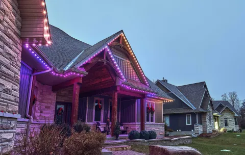 House with permanent holiday lighting installed along the roofline.